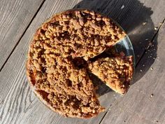 a pie sitting on top of a wooden table next to a slice missing from it