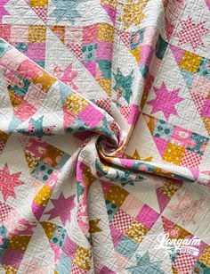 a pink and yellow quilt with stars on it