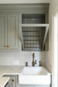 a kitchen with marble counter tops and gray cabinets