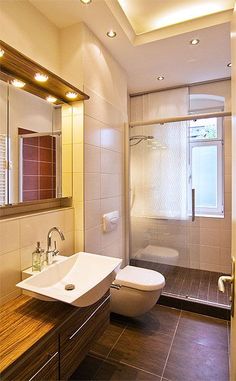 a bathroom with a sink, toilet and shower stall in the middle of the room