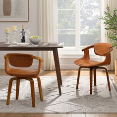 two chairs sitting at a table in front of a potted plant on the floor