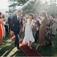 a bride and groom walking down the aisle