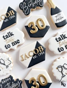 decorated cookies with black and white icing are arranged on a table for 30th birthday