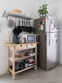 a kitchen with pots and pans hanging on the wall next to an open refrigerator