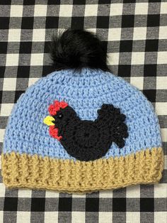 a crocheted hat with a black rooster on it