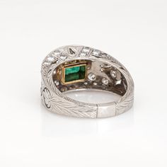 This is part of Chairish’s Fine Jewelry assortment.  Stylish and finely detailed emerald & diamond ring crafted in 900 platinum.  Center set emerald measures 5.5mm x 4mm. Diamonds total an estimated 0.75 carats (estimated at H-I color and VS2-SI2 clarity). Note: few chips to the emerald (visible under a 10x loupe).  With an emerald to the center the low dome band is set with sparkling diamonds. Etched palmette details add depth and texture, finished with fine milegrain. The ring is great worn al Hallmarked Oval Emerald Ring In Platinum, Oval Hallmarked Emerald Ring In Platinum, Art Deco Emerald Ring In Platinum, Fine Jewelry Emerald Ring With Platinum, Art Deco Platinum Emerald Ring, Art Deco Oval Emerald Ring With Brilliant Cut, Classic Platinum Emerald Ring, Art Deco Emerald Ring With Platinum, Formal Emerald Ring With Platinum Center Stone