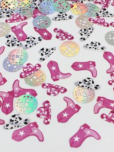 pink and silver confetti cutouts on white table with polka dot dots in the background