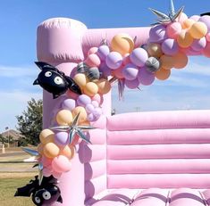 an inflatable arch decorated with balloons and decorations