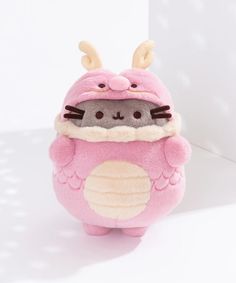 a pink stuffed animal with antlers on it's head and eyes, sitting in front of a white background