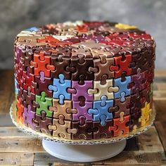 a multicolored cake with lots of puzzle pieces on it's icing