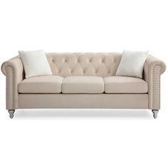 a beige couch with white pillows on it