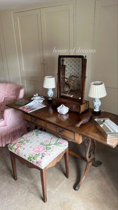 a desk with a chair, mirror and lamp on it