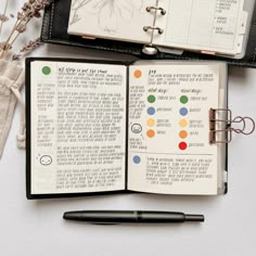 an open notebook with notes and pens on it next to a pocket watch, pen and other items