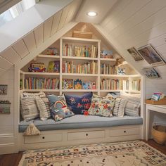 a room that has some bookshelves and pillows on the couch in it,