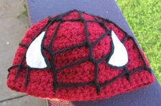 a crocheted spiderman hat with horns on the front and back of it