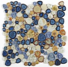 a blue and gold mosaic tile with circles on the bottom, surrounded by small rocks