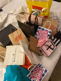 many shopping bags are on the bed