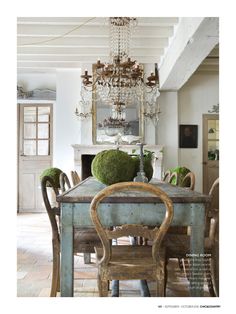 a dining room table with chairs and a chandelier hanging from it's ceiling