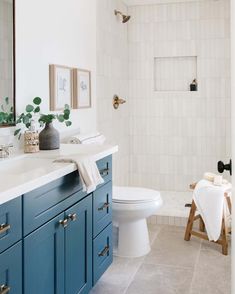 a bathroom with blue cabinets and a white toilet