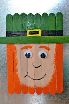 a wooden stick with a green hat on top of it and eyes drawn on the side