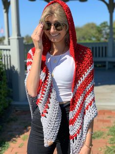 a woman wearing a red and white crocheted shawl