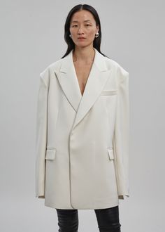 Color: Cream Mid weight woven fabric Oversized fit Boxy silhouette Peak lapel Padded shoulders Button cuffs Front flap pockets Darted detailing Concealed front button closure 100% Polyester Dry Clean By The Frankie Shop. Imported One Size White Semi-formal Outerwear With Button Cuffs, Elegant Oversized Blazer With Button Cuffs, Chic Oversized Blazer With Button Cuffs, Elegant White Oversized Blazer, Oversized Structured Blazer For Formal Occasions, Oversized Formal Blazer With Concealed Placket, Formal Oversized Blazer With Concealed Placket, Elegant Oversized Blazer, Elegant Oversized Blazer With Concealed Placket