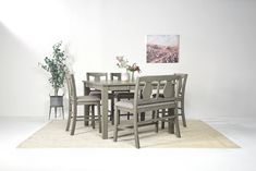 a dining room table and chairs in front of a white wall