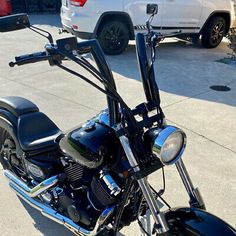 a black motorcycle parked next to a white car