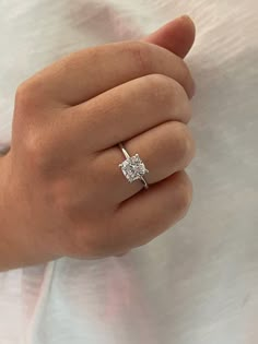 a woman's hand with a diamond ring on it