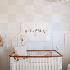 a baby crib in a white room with a sign on the wall above it