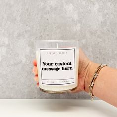 a hand holding a personalized candle that says your custom message here