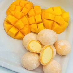 there are mangos and pieces of fruit on the white platter, ready to be eaten