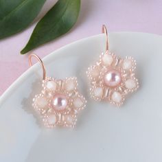 Our pink pearl flower earrings feature a beautiful crystal pearl, surrounded by pink seed beads that are hand woven into a floral pattern.  The beaded flowers dangle from handmade rose gold earrings creating a harmonious and eye-catching design. The coquette jewelry is ideal for spring and summer wardrobes adding a touch of glamour and femineity to your everyday look. The nature inspired earrings are lightweight and comfortable to wear, making them a great choice for all-day wear.    FIT:  The p Elegant Pink Flower Beaded Earrings, Elegant Rose Gold Beaded Earrings, Pink Pearl Beaded Earrings, Elegant Pink Round Bead Flower Earrings, Rose Gold Beaded Earrings With Round Beads, Rose Gold Beaded Round Earrings, Elegant Pink Round Beaded Flower Earrings, Earrings For Spring, Coquette Jewelry