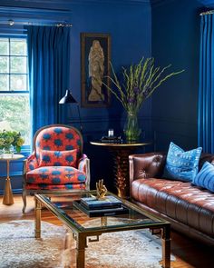 a living room with blue walls and leather furniture