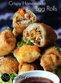 some fried food is stacked on top of each other with green onions and carrots