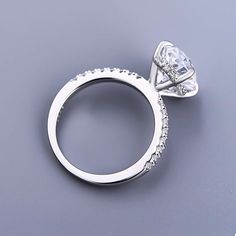 a white gold ring with two diamonds on the top and bottom, sitting on a gray surface