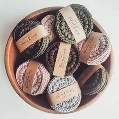 several crocheted balls in a wooden bowl with labels on the top and bottom