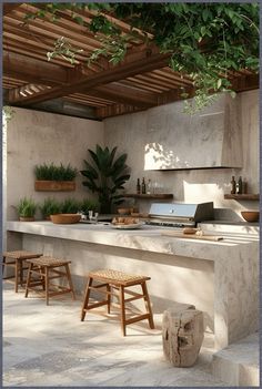 an outdoor kitchen with two stools next to the counter top and potted plants