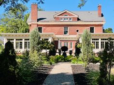 a large brick house surrounded by trees and bushes