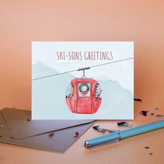 a greeting card featuring a cable car with the words ski - sons greetings on it