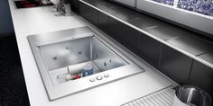 a stainless steel sink in a kitchen with blue and white tiles on the wall behind it