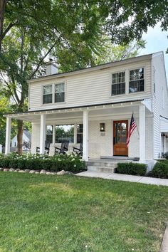 a white house with an american flag on the front porch