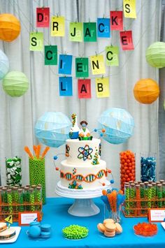 a birthday cake on a table in front of some decorations and paper lanterns hanging from the ceiling