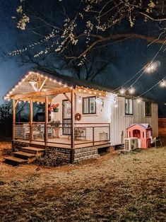 a small white house with lights on the roof