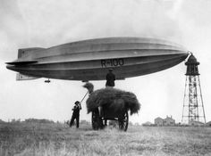 an old black and white photo of people standing in front of a large air balloon