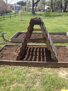 a wooden structure sitting in the middle of some dirt