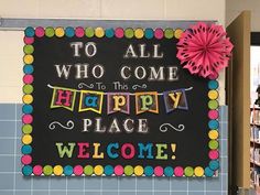 a welcome sign is displayed in front of a book shelf with books on it and a pink pom - pom