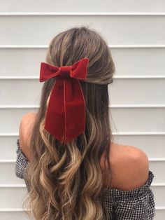 a woman with long hair wearing a red bow