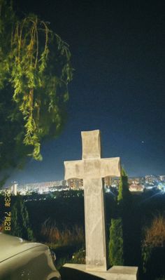 a white cross sitting on top of a cement slab