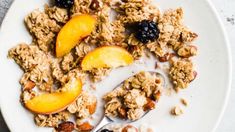 a white plate topped with granola and fruit